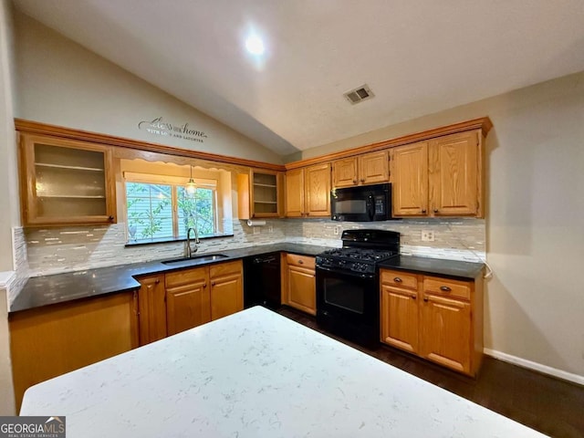 kitchen with sink, tasteful backsplash, black appliances, dark hardwood / wood-style flooring, and vaulted ceiling