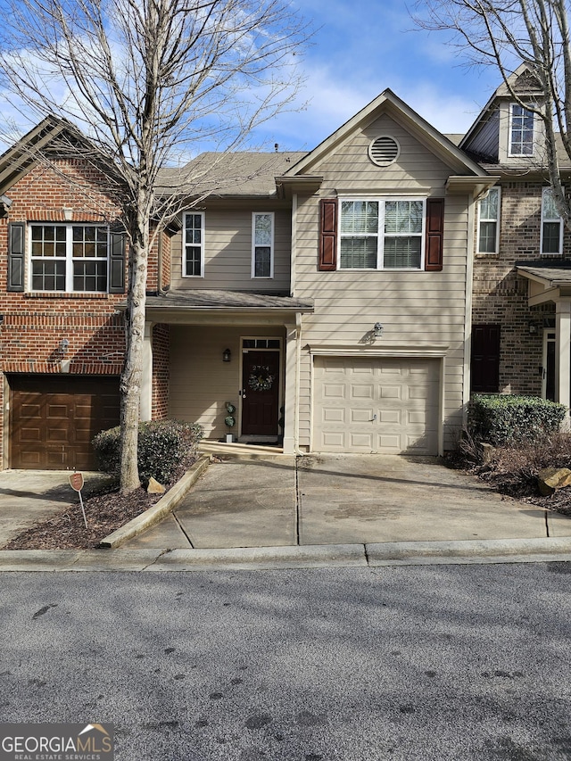 multi unit property featuring driveway and an attached garage