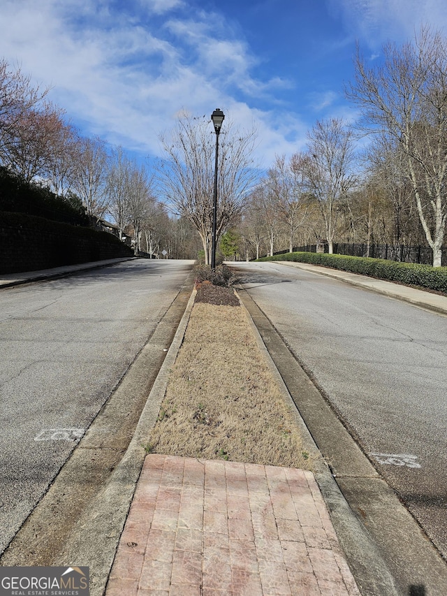 2764 Keystone Ave, Lithonia, GA 30058 - view of asphalt road with curbs, street lights, and sidewalks