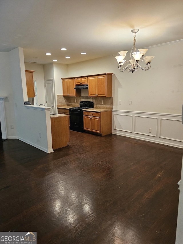 2764 Keystone Ave, Lithonia, GA 30058 - kitchen with black gas stove, a chandelier, brown cabinets, dark wood-type flooring, and decorative backsplash