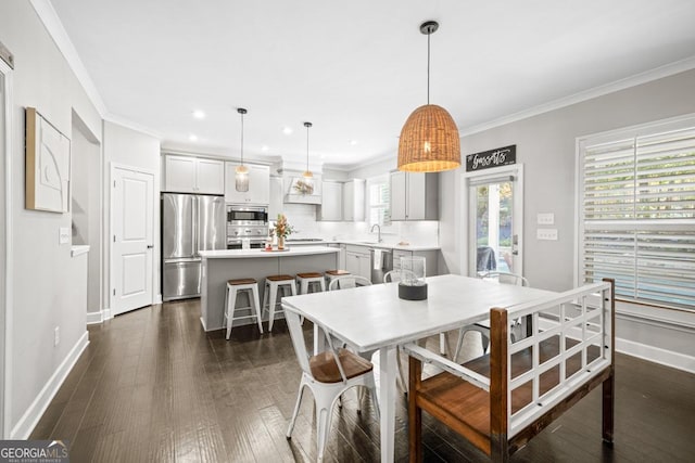 dining area featuring ornamental molding, dark wood-type flooring, and sink