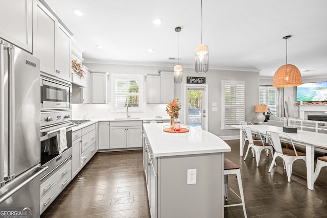 kitchen with pendant lighting, stainless steel appliances, a breakfast bar, and a kitchen island