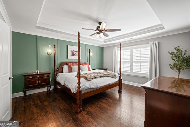 bedroom with dark hardwood / wood-style flooring and a tray ceiling