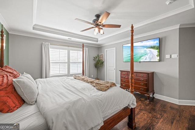 bedroom featuring ceiling fan, ornamental molding, a tray ceiling, and dark hardwood / wood-style flooring