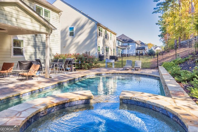 view of swimming pool with a patio and an in ground hot tub