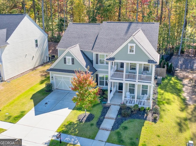 view of front of property with a garage, central air condition unit, a balcony, a front yard, and covered porch