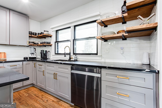 kitchen with gray cabinets, tasteful backsplash, dishwasher, sink, and light hardwood / wood-style floors