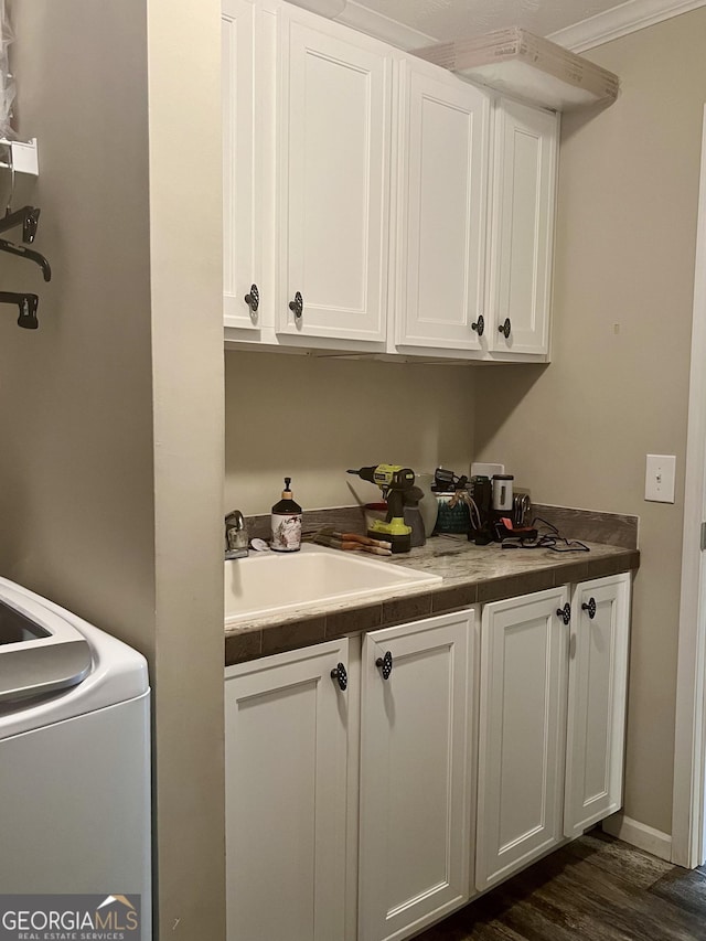 laundry room with sink, washer / dryer, dark wood-type flooring, and cabinets