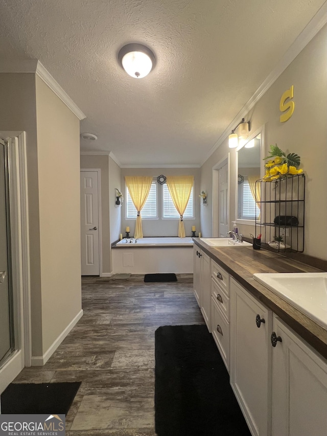 bathroom featuring wood-type flooring, ornamental molding, and a textured ceiling