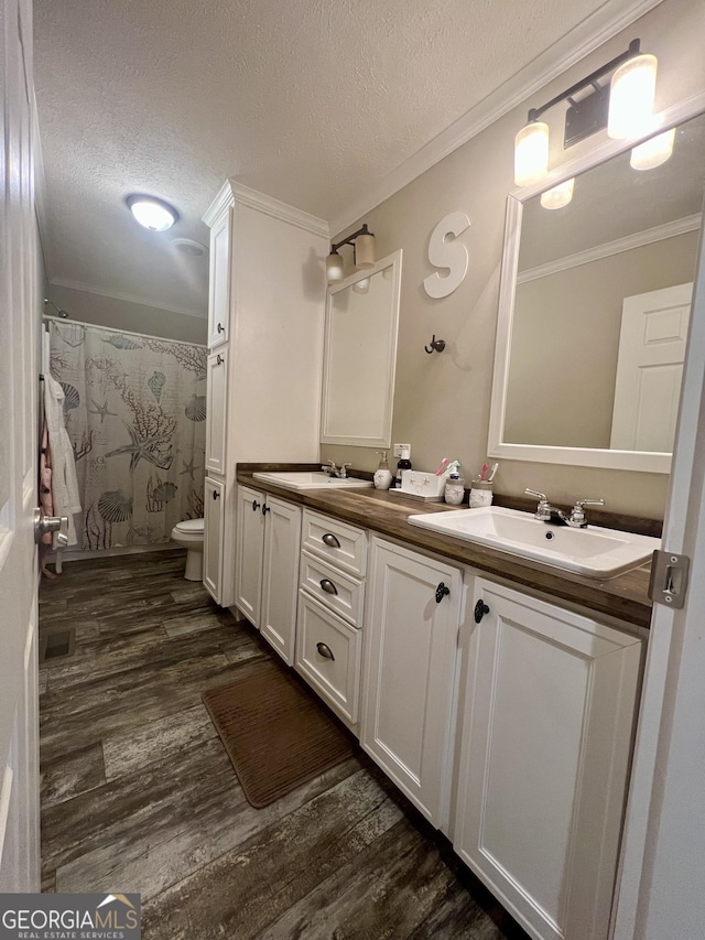 bathroom with vanity, toilet, hardwood / wood-style floors, and a textured ceiling