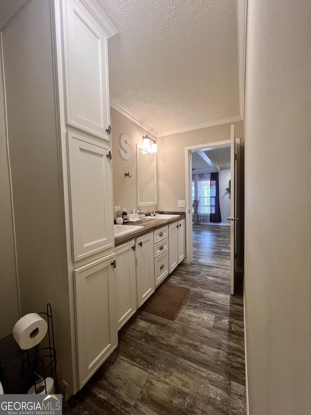 bathroom featuring ornamental molding, wood-type flooring, a textured ceiling, and vanity