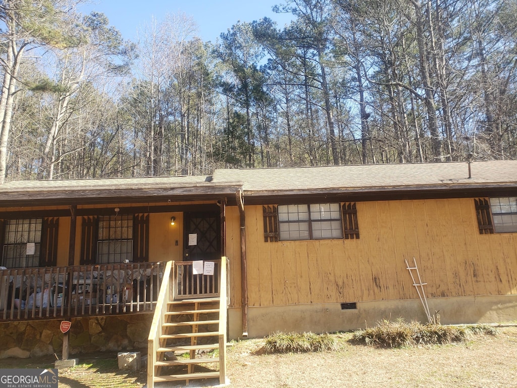 view of front of house with a porch, roof with shingles, and crawl space