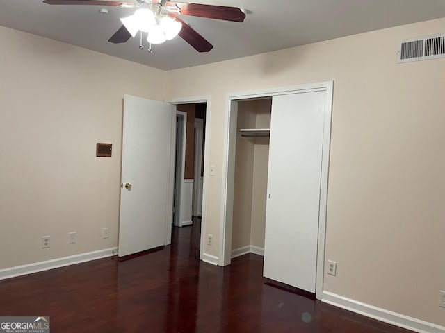 unfurnished bedroom featuring ceiling fan, dark hardwood / wood-style flooring, and a closet