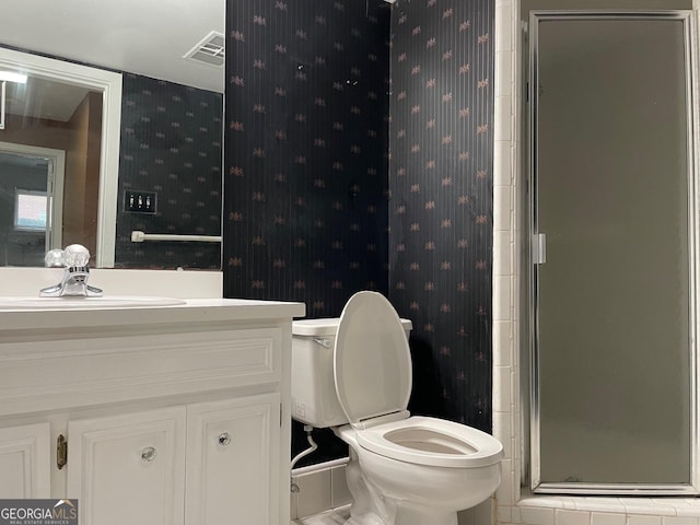 bathroom with vanity, a shower with shower door, and toilet