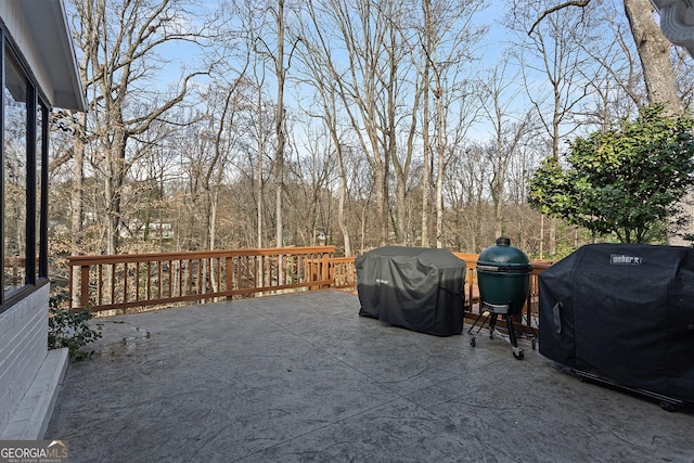 wooden terrace featuring area for grilling and a patio