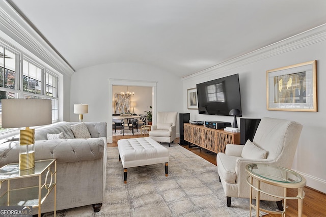 living room with vaulted ceiling, hardwood / wood-style floors, and a chandelier