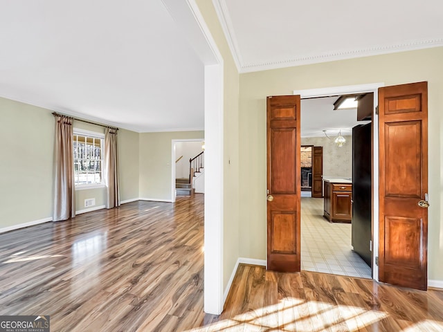 interior space featuring crown molding and light hardwood / wood-style floors