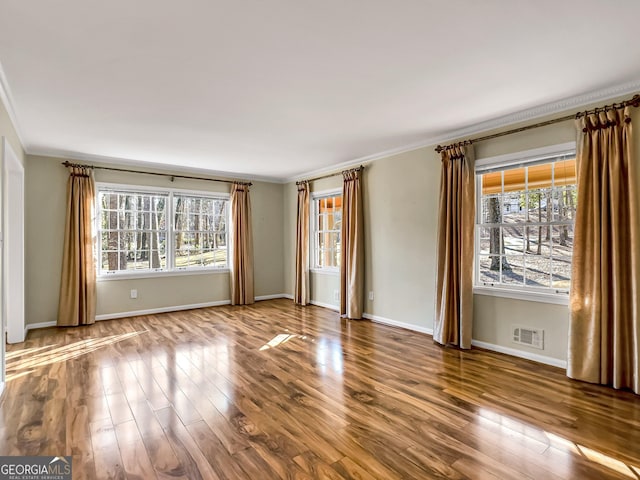 spare room featuring crown molding and hardwood / wood-style floors