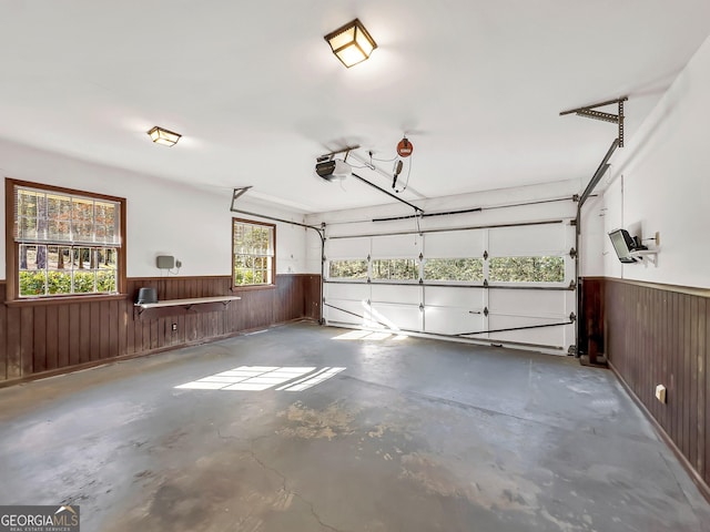 garage with a garage door opener and wood walls