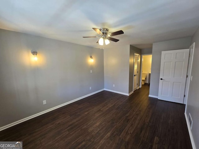 empty room with ceiling fan and dark hardwood / wood-style flooring