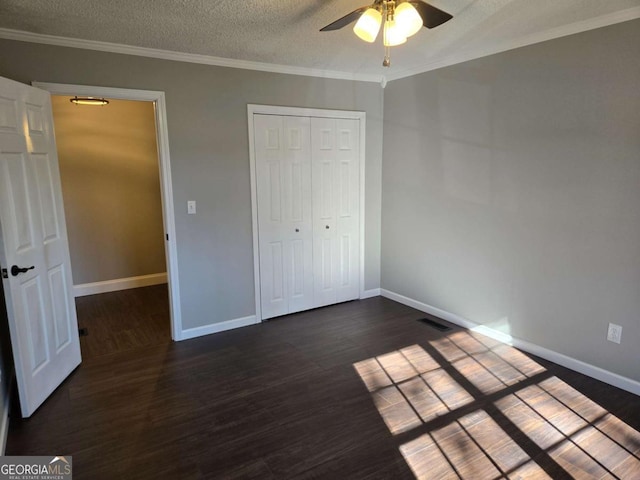 unfurnished bedroom with a closet, ornamental molding, dark hardwood / wood-style flooring, and a textured ceiling