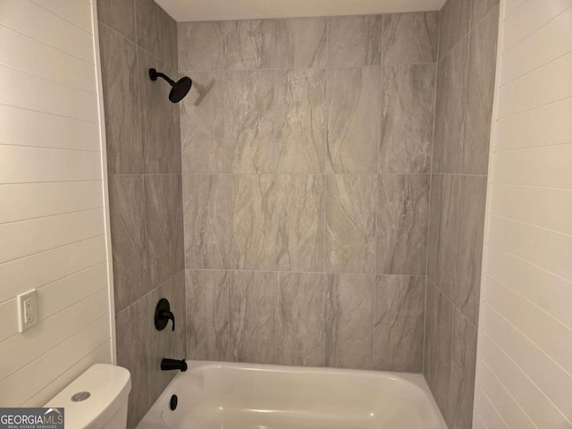 bathroom with tiled shower / bath and toilet