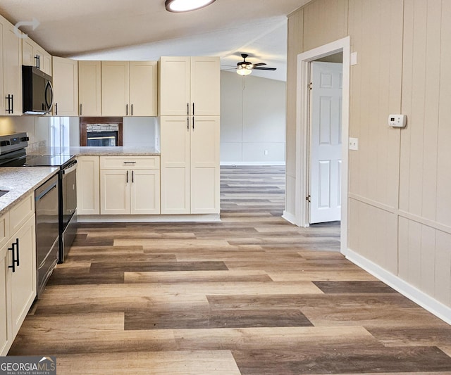 kitchen with cream cabinets, black electric range oven, vaulted ceiling, ceiling fan, and light hardwood / wood-style floors