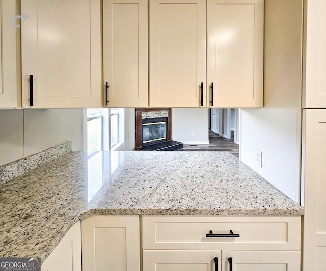 kitchen featuring a fireplace and light stone countertops