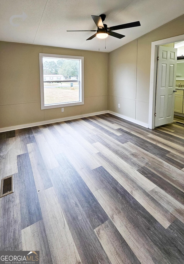 empty room featuring hardwood / wood-style flooring, a textured ceiling, and ceiling fan