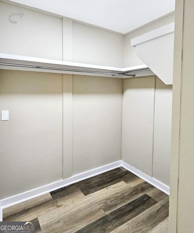 walk in closet with dark hardwood / wood-style floors