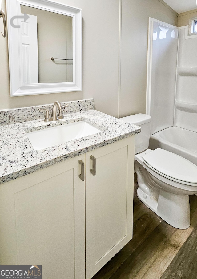 full bathroom with vanity, hardwood / wood-style flooring, shower / tub combination, and toilet