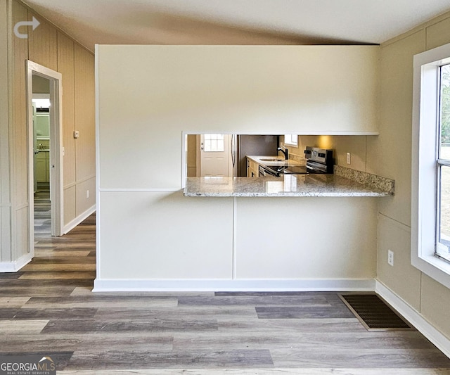 kitchen with range with electric stovetop, hardwood / wood-style flooring, sink, and kitchen peninsula