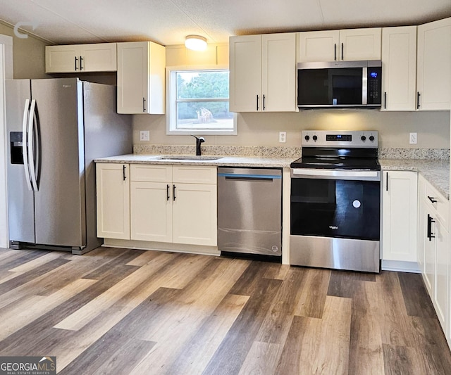 kitchen featuring stainless steel appliances, sink, and white cabinets