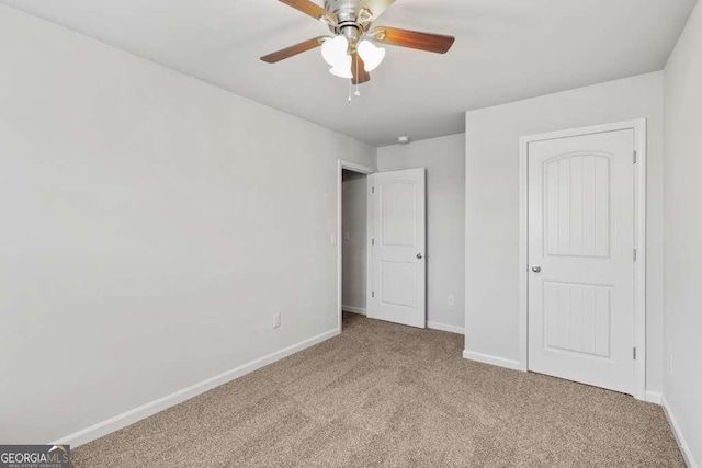 unfurnished bedroom featuring ceiling fan and carpet