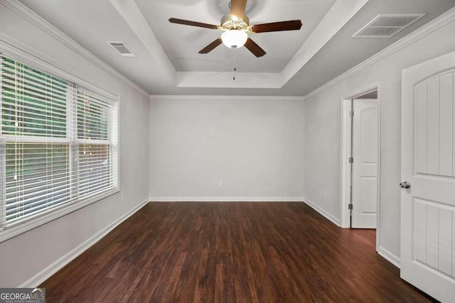 empty room featuring ceiling fan, a tray ceiling, and dark hardwood / wood-style flooring