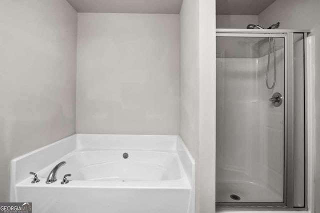 bathroom featuring separate shower and tub