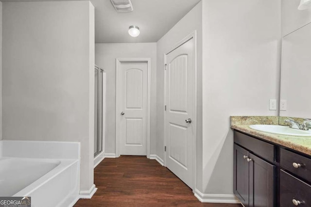 bathroom with vanity, shower with separate bathtub, and hardwood / wood-style floors