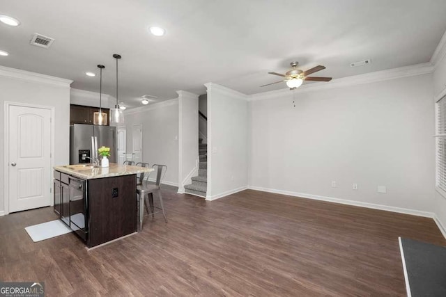 kitchen featuring pendant lighting, dark brown cabinets, an island with sink, and stainless steel refrigerator with ice dispenser