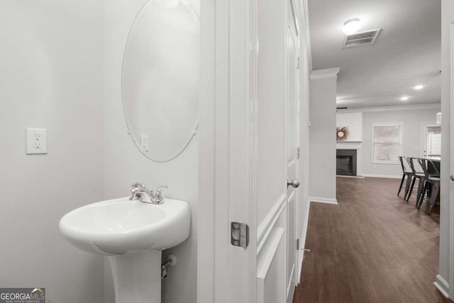 bathroom featuring hardwood / wood-style flooring and crown molding