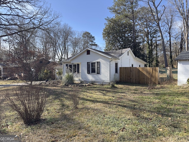 view of property exterior with a porch and a lawn