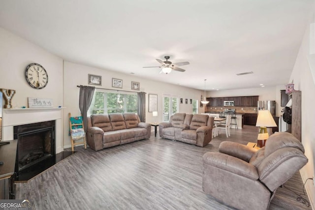 living room featuring dark wood-type flooring and ceiling fan