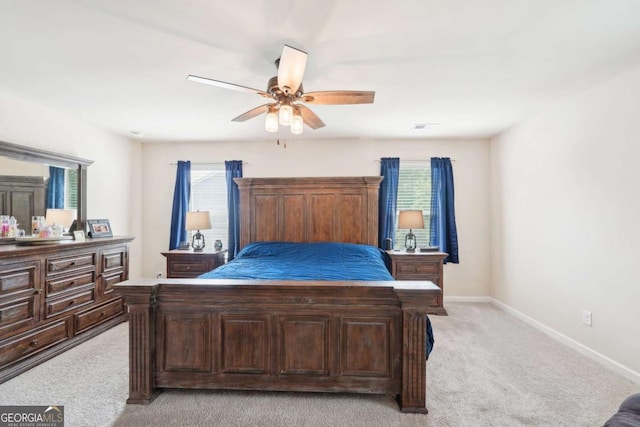 bedroom with multiple windows, light colored carpet, and ceiling fan