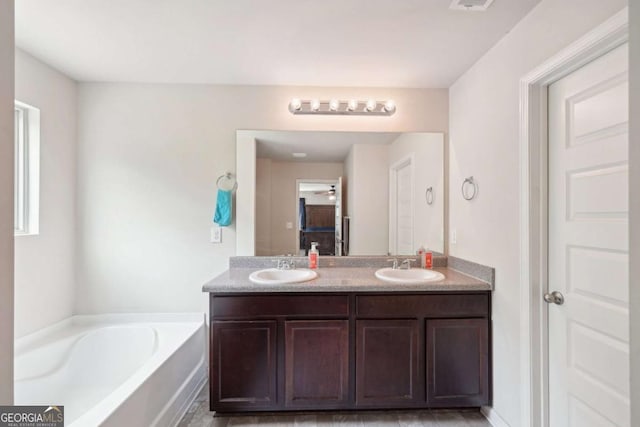 bathroom with vanity and a tub to relax in