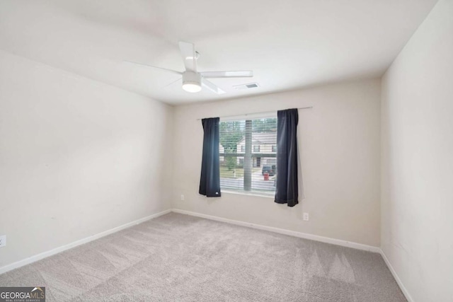 carpeted spare room featuring ceiling fan