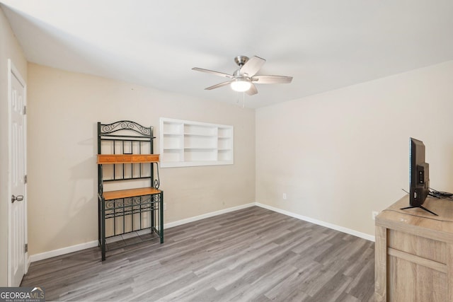 interior space with hardwood / wood-style flooring, ceiling fan, and built in features