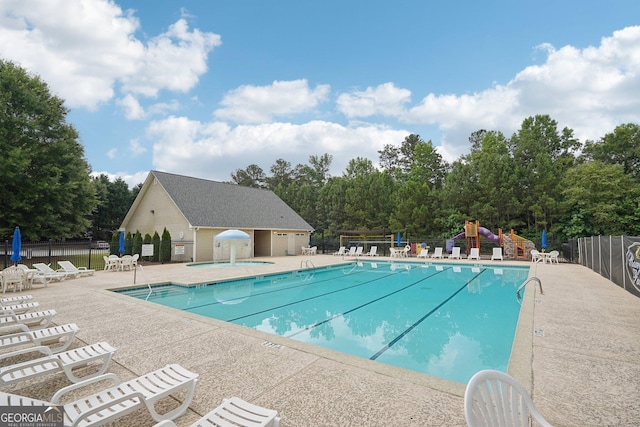 view of swimming pool with a patio area and a playground