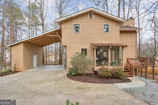 rear view of house featuring a carport and a deck