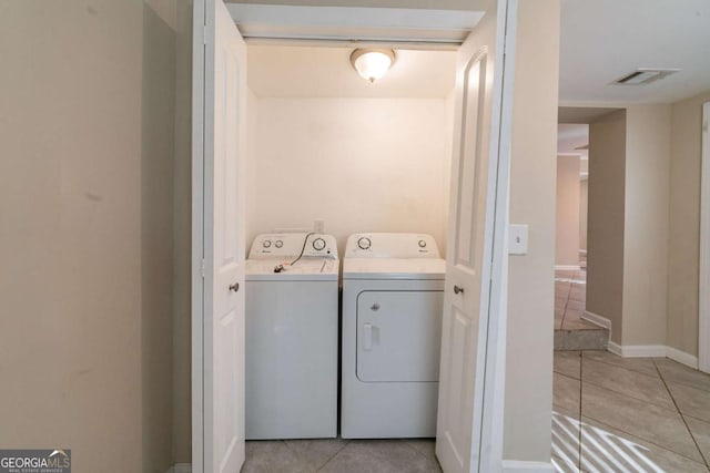 laundry area featuring light tile patterned floors and independent washer and dryer