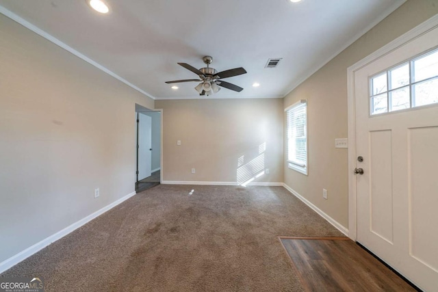 carpeted entryway with crown molding and ceiling fan