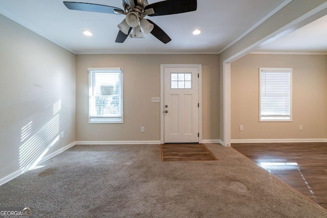 foyer with dark colored carpet and ornamental molding